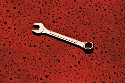 Close-up of wrench on red abstract background