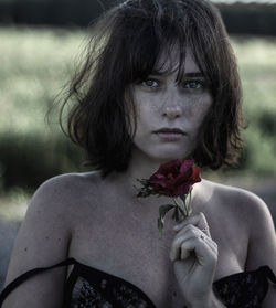Portrait of young woman holding flower