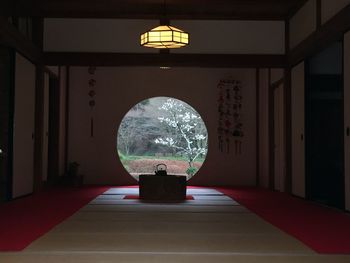 Illuminated lamp on table against wall