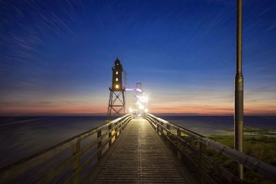 Pier on sea at sunset