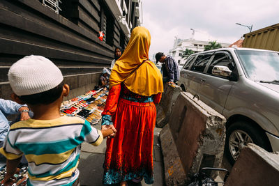 Rear view of people standing on street