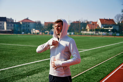 Caucasian man at stadium track preparing for fitness exercises, helathy lifestyle