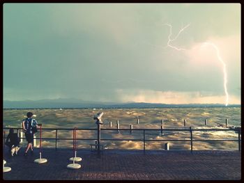 People against cloudy sky