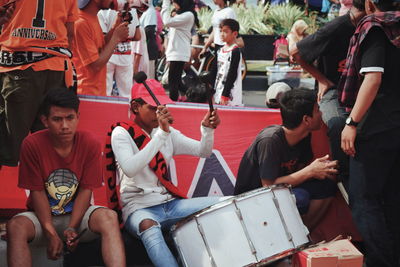 Group of people sitting on street in city