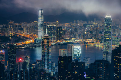 Illuminated buildings in city against sky at night