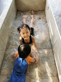 High angle view of mother and daughter in water