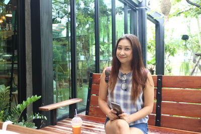 Portrait of smiling young woman sitting on table