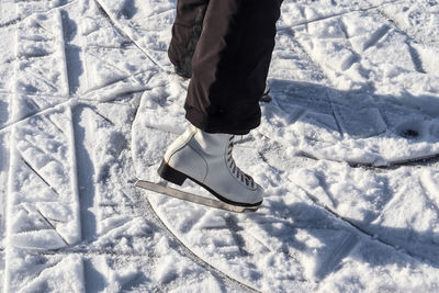 Low section of person standing on snow covered land