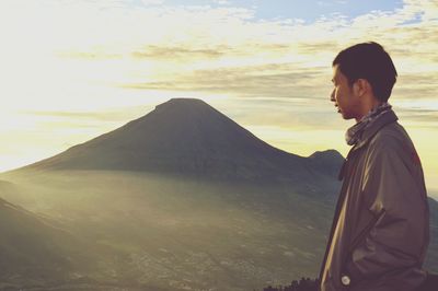 Woman looking at mountains during sunset