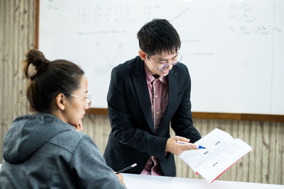 Young man and woman standing on table