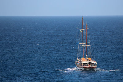 Ship sailing in sea against clear sky