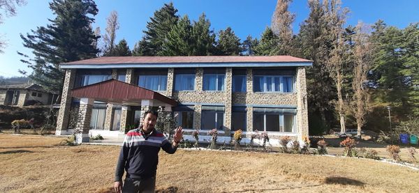 People standing outside house against building