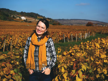 Portrait of smiling woman standing in vineyard