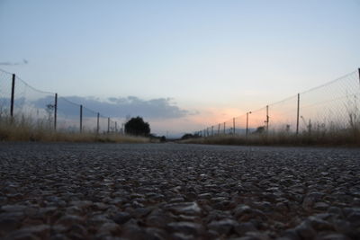 Surface level of land against sky during sunset