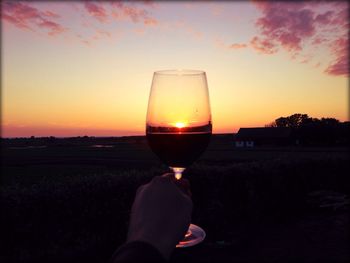 Hand holding hot air balloon at sunset