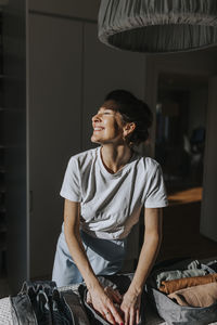 Woman folding clothes in bedroom