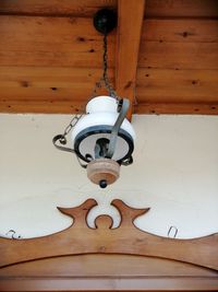 Low angle view of electric lamp hanging on wall