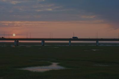 Bridge over river against cloudy sky