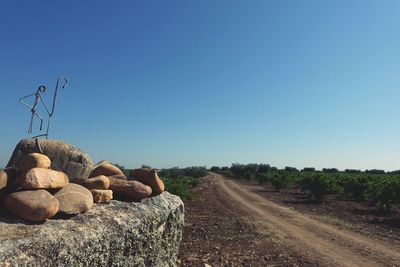 Rocks on land against clear blue sky