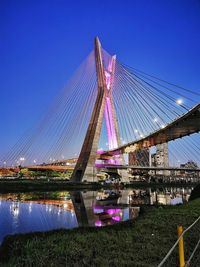 Low angle view of suspension bridge against blue sky