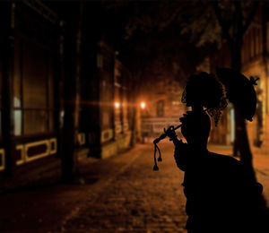 Side view of silhouette man holding illuminated at night