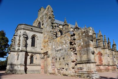 Low angle view of old building against blue sky