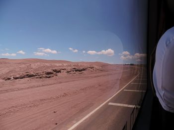 Scenic view of desert road against sky