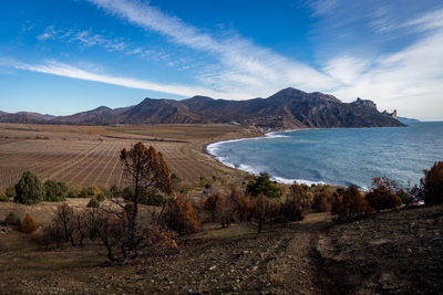 Scenic view of sea and mountains against sky