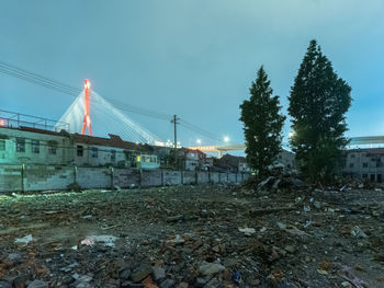 Construction site on field by buildings against sky