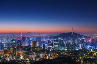 Illuminated cityscape against sky at night