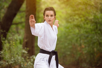 Portrait of young man exercising on field