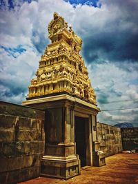 Low angle view of temple against cloudy sky