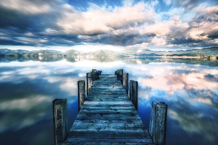 water, sky, pier, cloud - sky, wood - material, scenics, beauty in nature, tranquility, tranquil scene, cloudy, the way forward, lake, railing, nature, jetty, weather, boardwalk, built structure, idyllic, cloud