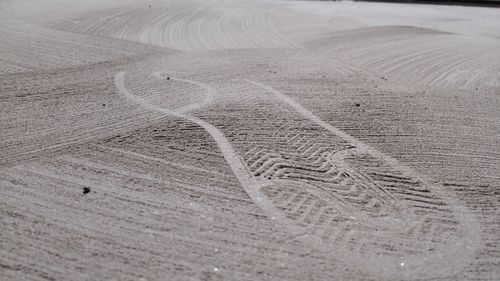 High angle view of tire tracks on sand