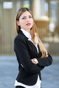 Portrait of young businesswoman standing in city