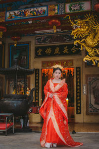 Young woman in traditional clothing standing at temple