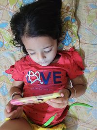 High angle view of girl lying on bed