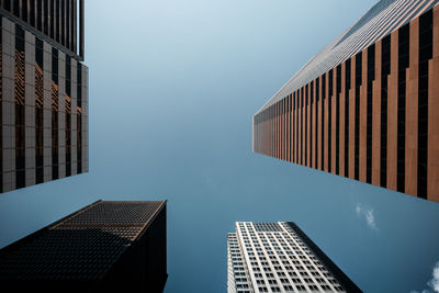 Low angle view of towers against blue sky in city