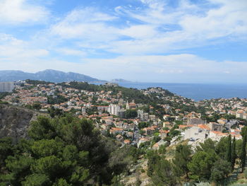 Aerial view of townscape by sea against sky