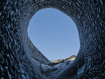 Low angle view of wall against clear blue sky