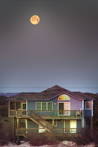 Built structure on beach against sky at night