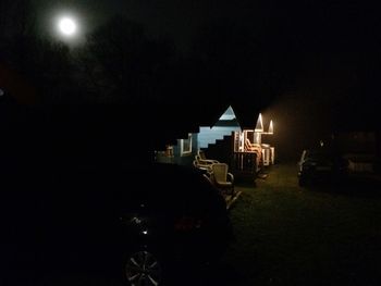 Illuminated ferris wheel against sky at night
