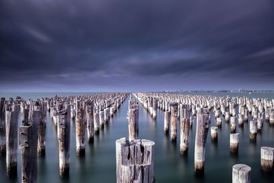 Pier over lake against sky at night