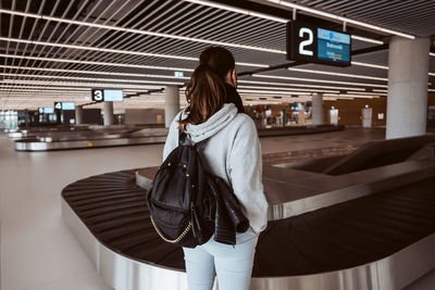 Rear view of young woman standing in city