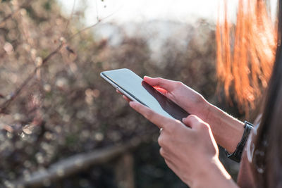 Midsection of woman using mobile phone