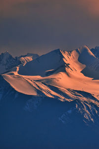 Scenic view of snowcapped mountains against sky during sunset