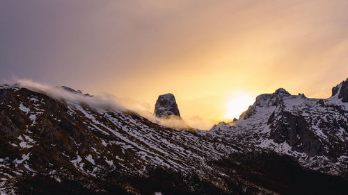 Scenic view of snowcapped mountains against sky during sunset