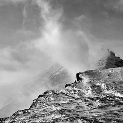 Scenic view of mountains against cloudy sky