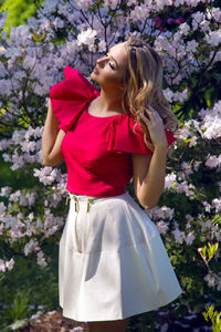 Portrait of a young girl blondes with make-up in the cherry sakura pink white in a white skirt