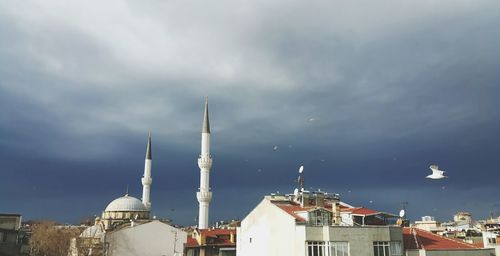 High section of buildings against cloudy sky